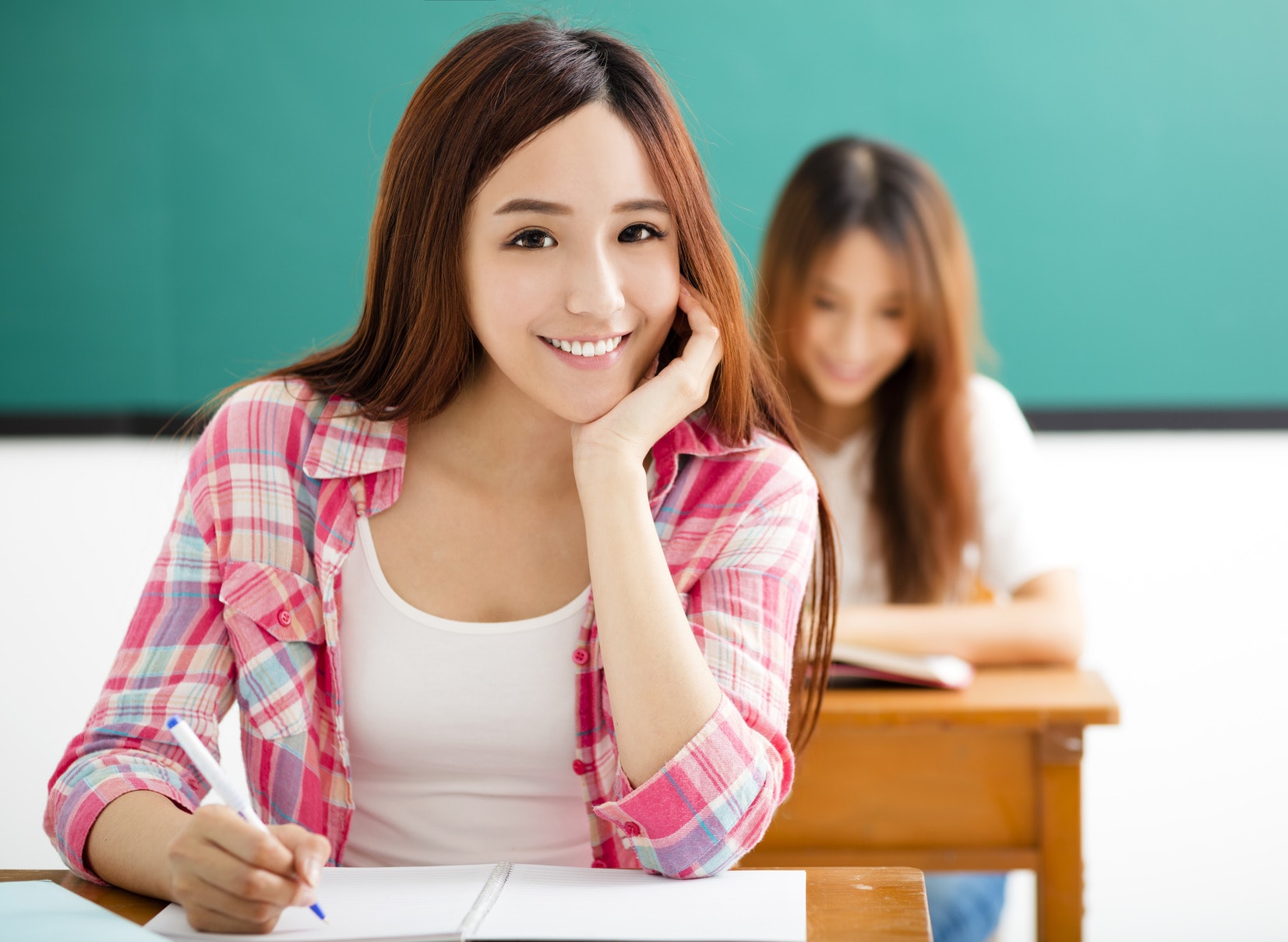 photodune-12929482-smiling-young-student-with-others-in-the-classroom-m-min